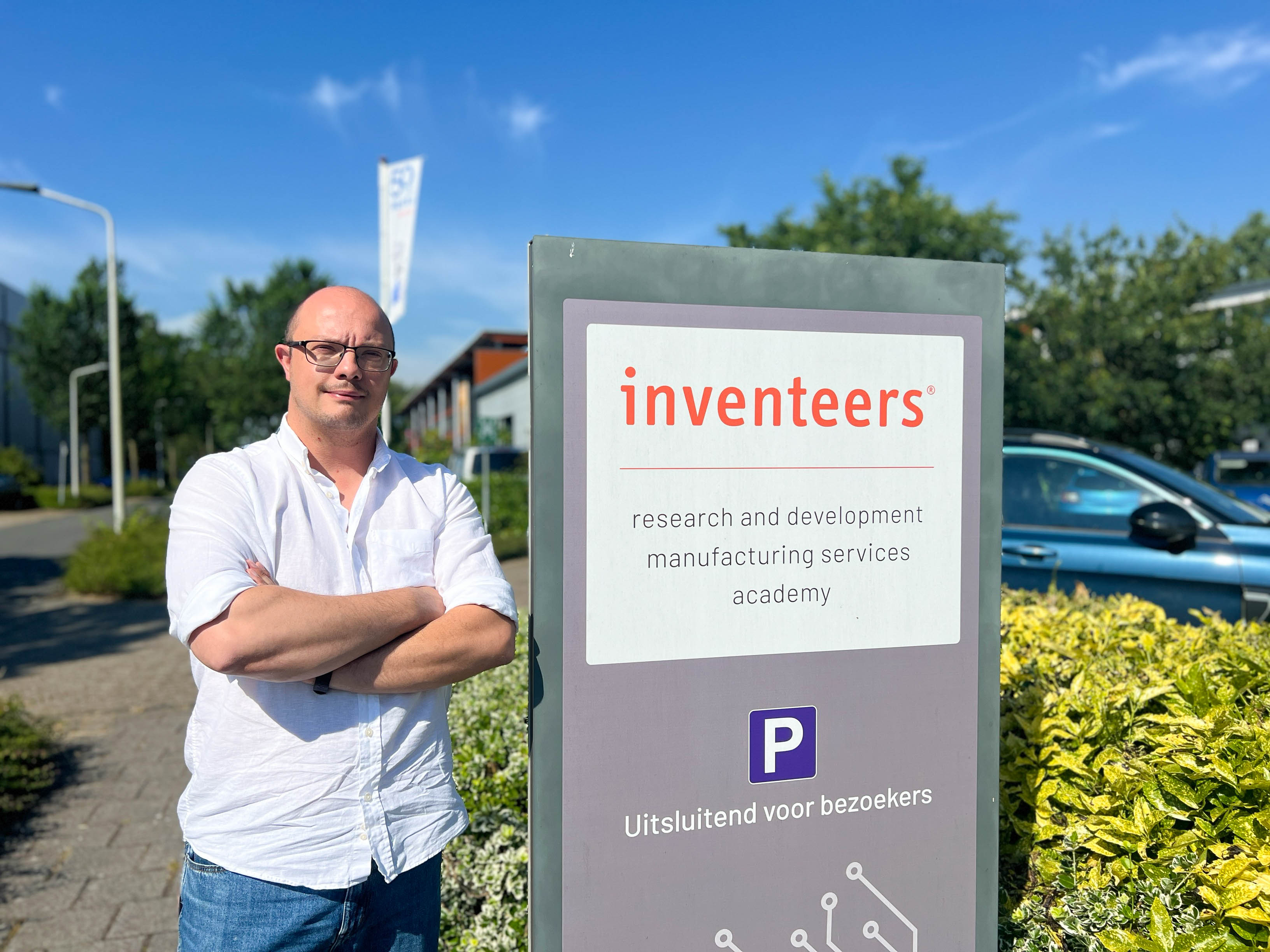 Alumnus Maarten Pieters buiten bij het bord van Inventeers