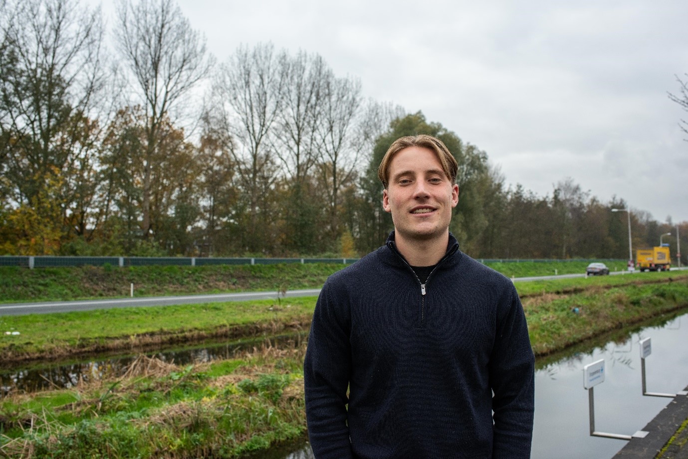 Mick poseert buiten voor zijn bedrijf